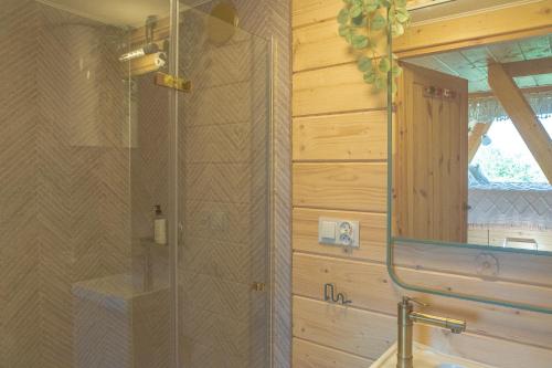 a bathroom with a shower with a sink and a mirror at Alemiło mini - domek z balią i widokiem na Babią Górę in Zawoja