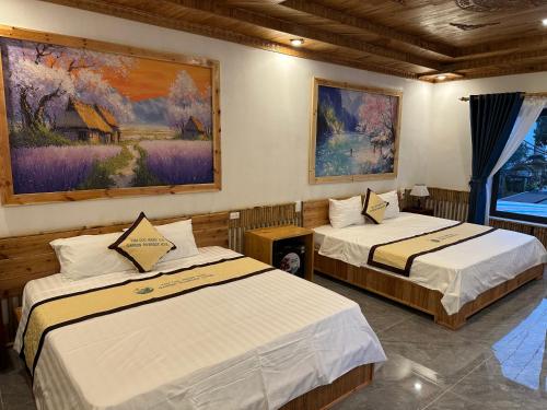 a room with two beds and a painting on the wall at Tam Coc Vinh Thinh Homestay in Ninh Binh
