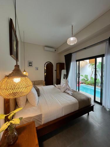 a bedroom with a bed with a view of a pool at Djeladjah Villa in Ngingas