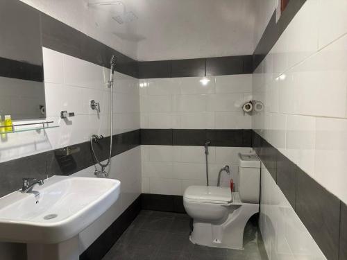 een badkamer met een wit toilet en een wastafel bij Surf Dine in Matara