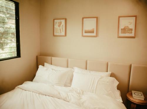 een bed met witte lakens en kussens in een kamer bij Filo La Union in San Juan