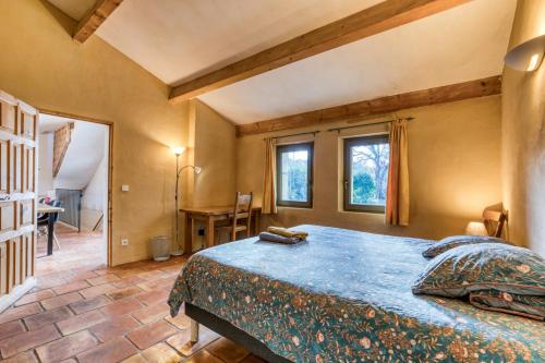 ein Schlafzimmer mit einem großen Bett in einem Zimmer in der Unterkunft Gîte avec piscine de 25 m et spa in Saint-Mathieu-de-Tréviers