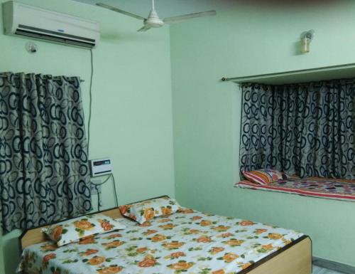 a small bedroom with a bed and a window at Msquare guest house in Godāvari