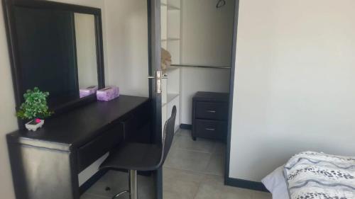 a bedroom with a black desk and a mirror at Home away from home in Midrand