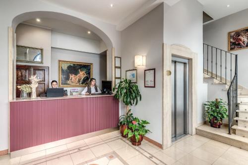 two women working at a counter in a lobby at Hotel Galileo in Florence