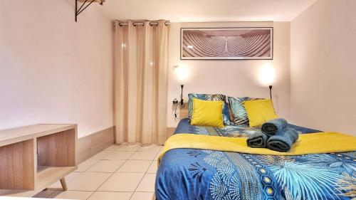 een slaapkamer met een bed met gele en blauwe lakens bij Gîte Renaud et Lauren - Terrace - Horbourg-Wihr in Horbourg