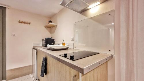 een keuken met een wastafel en een spiegel op een aanrecht bij Gîte Renaud et Lauren - Terrace - Horbourg-Wihr in Horbourg