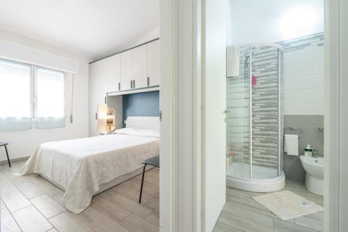 een witte slaapkamer met een bed en een badkamer bij Sole e Mare Buggerru - Appartamento in Buggerru