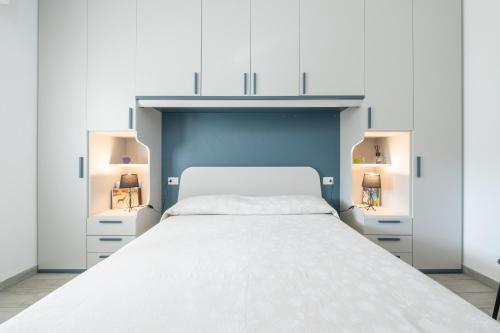 een slaapkamer met een wit bed en 2 verlichting bij Sole e Mare Buggerru - Appartamento in Buggerru