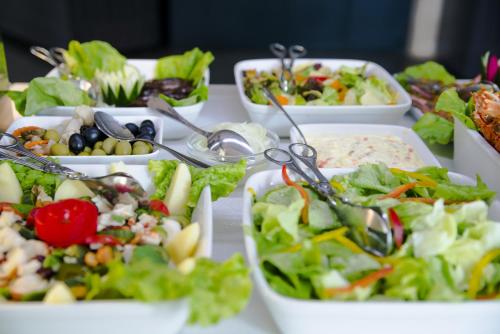 a table topped with bowls of salad and vegetables at Hotel Continental Luanda in Luanda