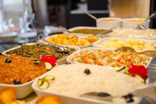 a table topped with trays of different types of food at Hotel Continental Luanda in Luanda