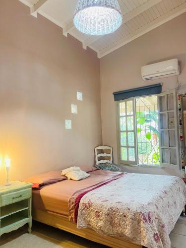 ein Schlafzimmer mit einem Bett und einem Stuhl und einem Fenster in der Unterkunft Tuchita House en Cataratas con piscina compartida parrilla, cochera in Puerto Iguazú