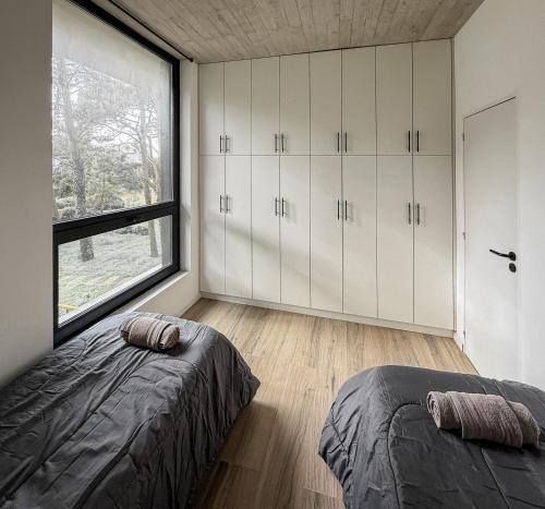 een slaapkamer met witte kasten en een groot raam bij Il Buco in Carilo