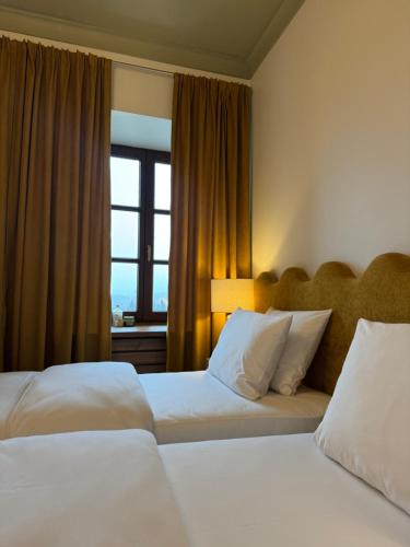 a hotel room with two beds and a window at Villa MERLINI w sercu Starego Miasta, Grodzka 19 Lublin in Lublin