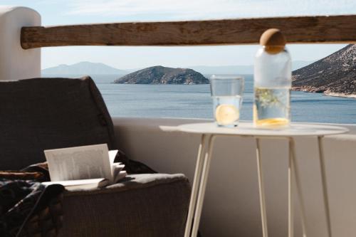 a table with a bottle and a glass on it at PhosAlos Apartments in Aegiali