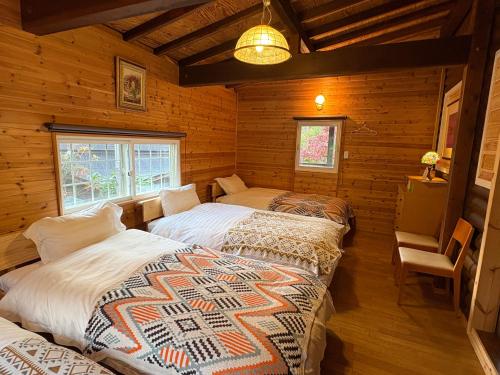 a bedroom with two beds in a log cabin at beau lac biwako annex in Takashima