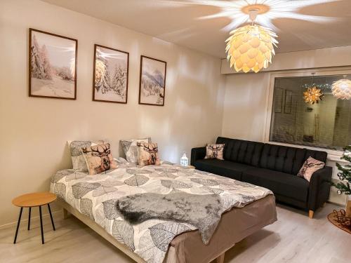 a bedroom with a bed and a couch at Warm Wooden Home in Rovaniemi in Rovaniemi