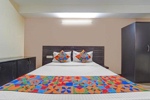 Un dormitorio con una cama con una colcha colorida encima. en Via AB Top, en Coimbatore