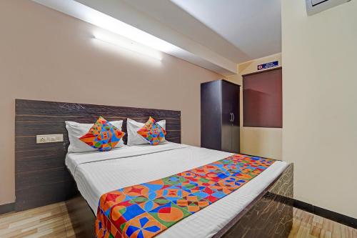 1 dormitorio con 1 cama con sábanas y almohadas coloridas en Via AB Top, en Coimbatore