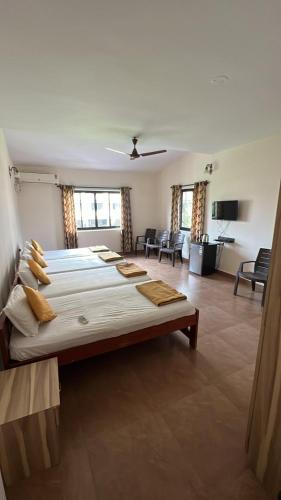 a large bedroom with a large bed and a living room at Dona Helena Holiday Home in Madgaon