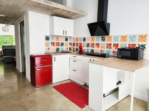 a kitchen with white cabinets and a red refrigerator at Casa Patio del Vino in Ciudad-Rodrigo