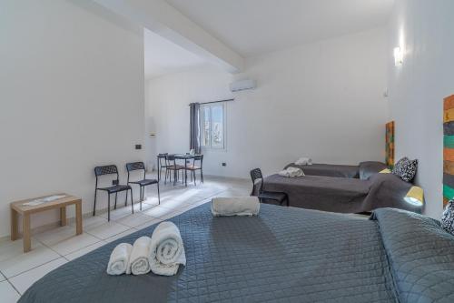 a bedroom with a bed and a living room at Fiumara Val Di Noto Country Rooms in Noto