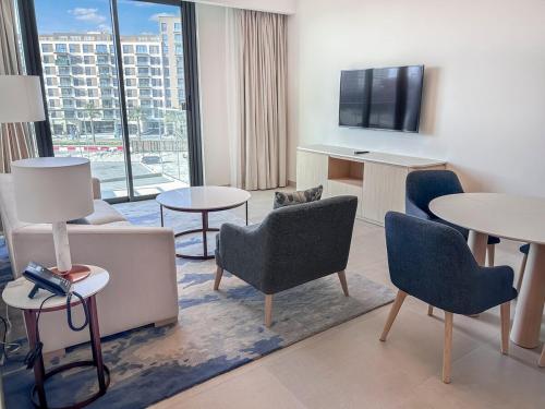 een hotelkamer met stoelen en tafels en een groot raam bij Marrasi Vista by the address in Muharraq