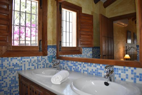 a bathroom with two sinks and two mirrors at Finca Durillo with private Pool in Cómpeta