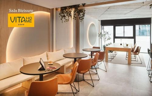 a living room with a couch and tables and chairs at Vita Home Lanzarote I Deluxe Apartments in Arrecife