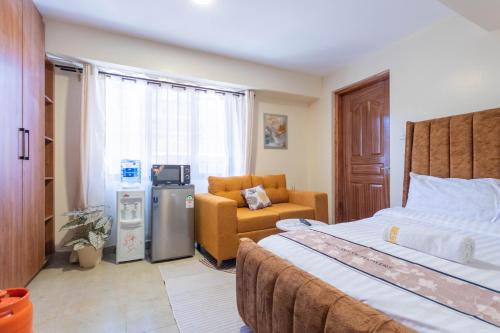 Un dormitorio con una cama, un sofá y una silla. en Hazel Studio with free WI-FI, en Nanyuki