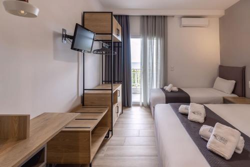 a small hotel room with two beds and a television at Azzurro in Nei Poroi