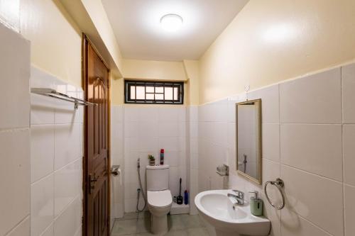 Un baño con inodoro, lavabo y espejo. en Hazel Studio with free WI-FI, en Nanyuki