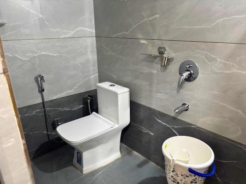 a bathroom with a toilet and faucets on the wall at The Mayfair Hotel in Jāmb