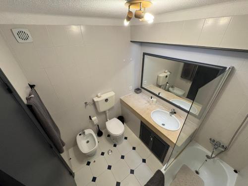 een badkamer met een toilet, een wastafel en een spiegel bij Coral By Albufeira Rental in Albufeira