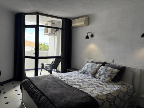 een slaapkamer met een bed en een deur naar een balkon bij Coral By Albufeira Rental in Albufeira