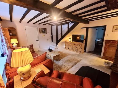 a living room with leather couches and a tv at Charming 3 bed kent Cottage in Chilham