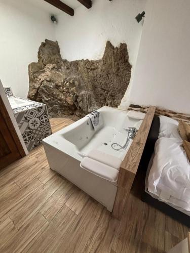 eine Badewanne in einem Raum mit einem Felsen in der Unterkunft El Tumbao con romántica bañera de hidromasaje para dos in Laroya
