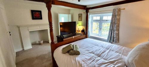 a bedroom with a large bed with a large window at Charming 3 bed kent Cottage in Chilham
