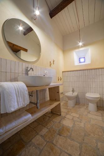 a bathroom with a sink and a toilet and a mirror at Vento Forte - eco dimore nel borgo in Civita