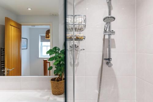 a shower stall in a bathroom with a mirror at Saxon Mews in Wareham