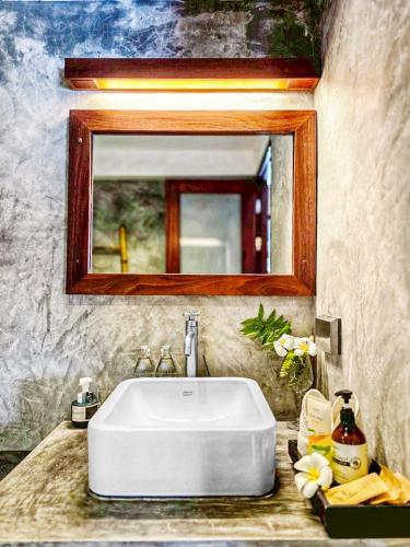 a white sink in a bathroom with a mirror at Langkhai Garden in Ko Tao