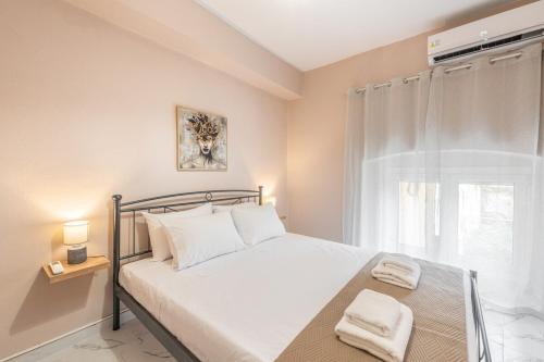 a bedroom with a white bed with a window at Spyridoula House in Corfu
