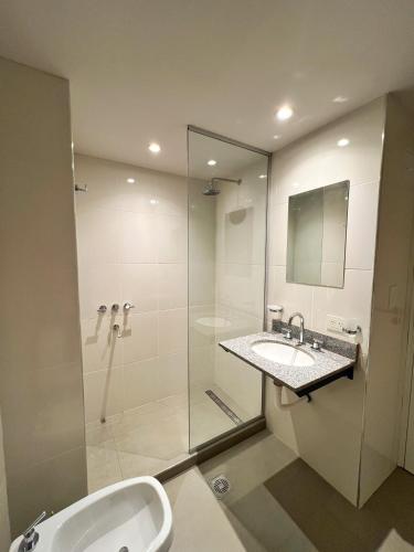 a bathroom with a glass shower and a sink at Otero Coliving - Studio Entero U1 in San Salvador de Jujuy