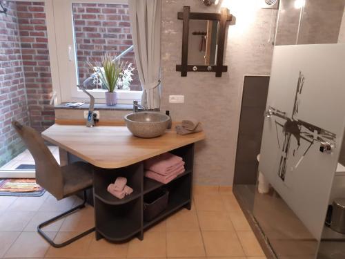 a kitchen with a table and a sink and a refrigerator at Pension Zur Mühle in Nettetal