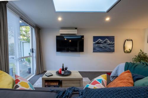 a living room with a couch and a tv at Bright Modern Guesthouse - Free Parking, Near CBD in Christchurch