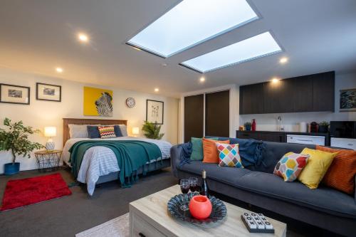 a living room with a couch and a bed at Bright Modern Guesthouse - Free Parking, Near CBD in Christchurch
