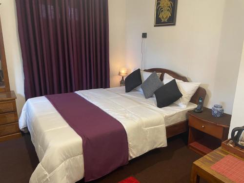 a hotel room with a large bed with pillows at Penthouse Bandarawela in Bandarawela