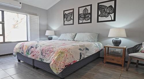 a bedroom with a bed and three pictures on the wall at Stripes & Sunsets Marloth Park in Marloth Park