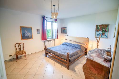 a bedroom with a bed and a chair in it at La casa in campagna in Cascina Grossa