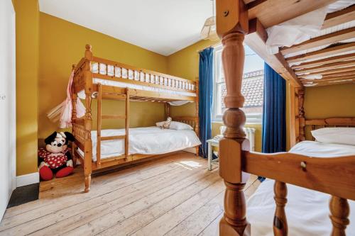 two bunk beds in a room with yellow walls at Edinburgh House in Burnham Market
